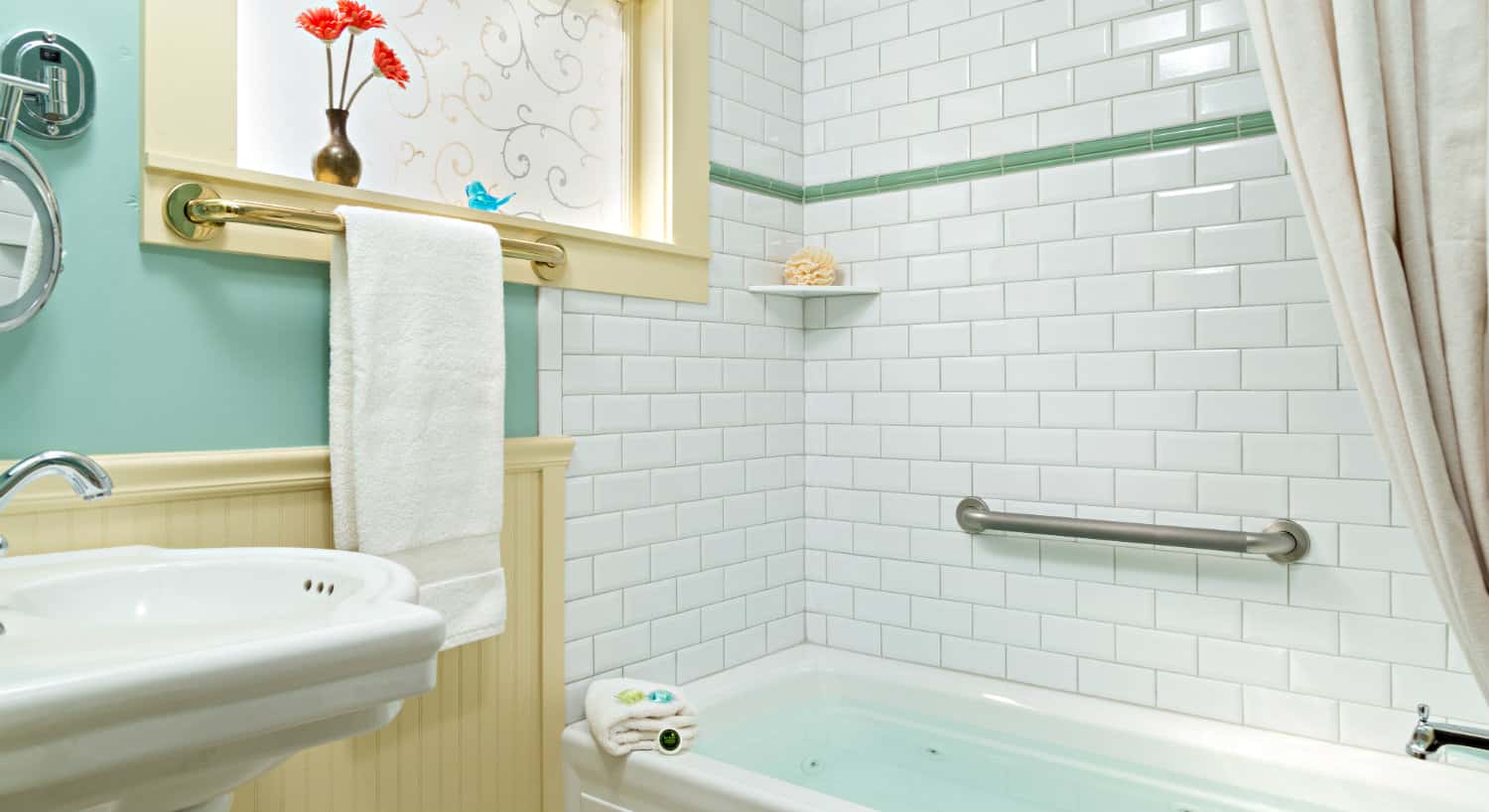 Bathroom with cream chair rail, aqua walls and a shower-tub combo with white subway tile.