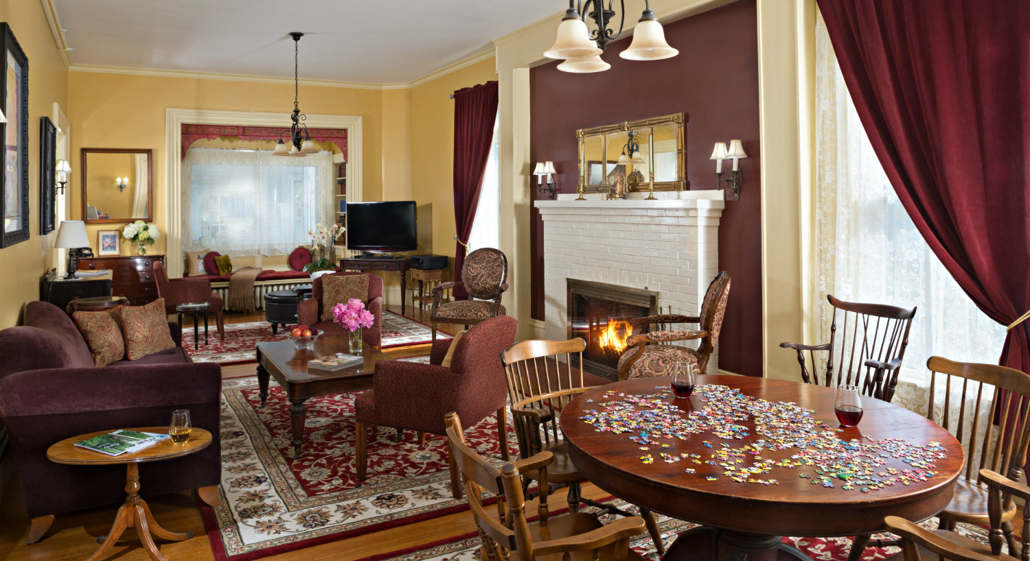 Public area with seating in front of fireplace and a table and chairs for games and puzzles.